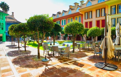 The plaza at the marina — orange trees in planters, a fountain and café tables