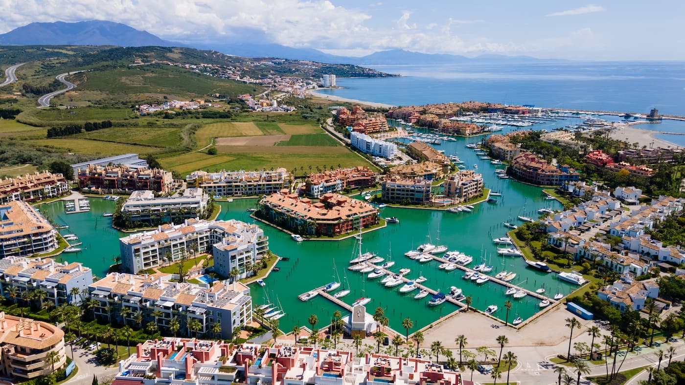 Aerial view of Sotogrande Marina with apartment buildings around canals full of moored boats